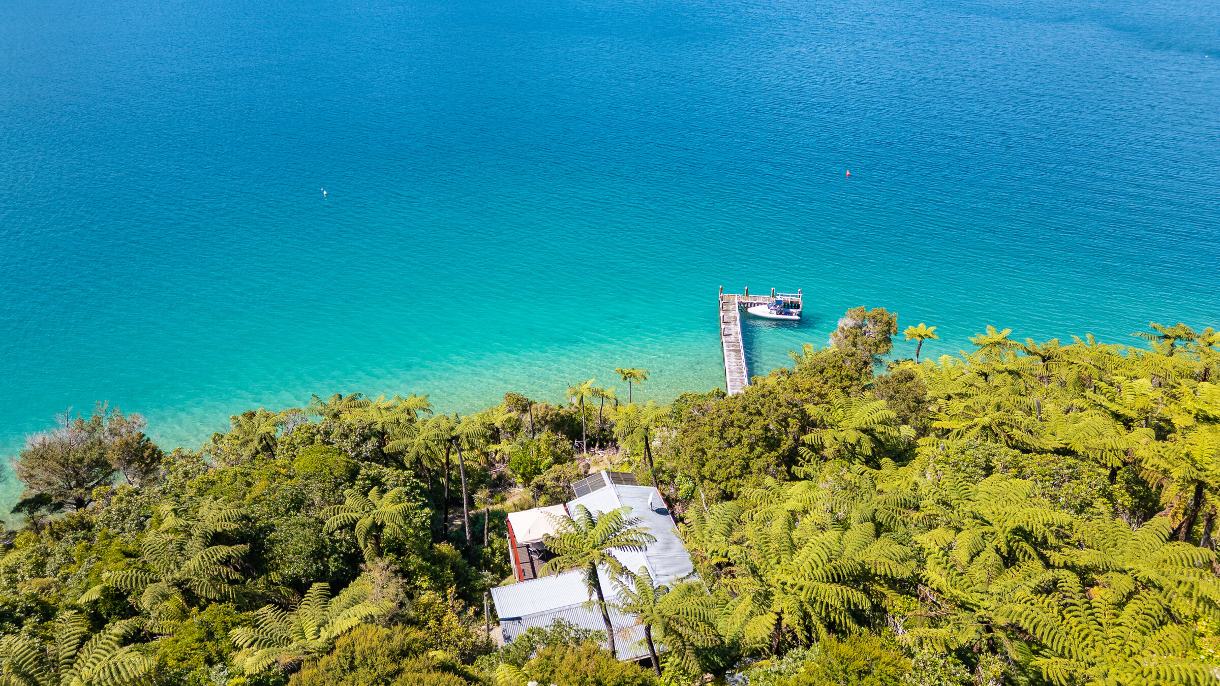 Aerial view of a Marlborough Sounds lodge on turquoise water