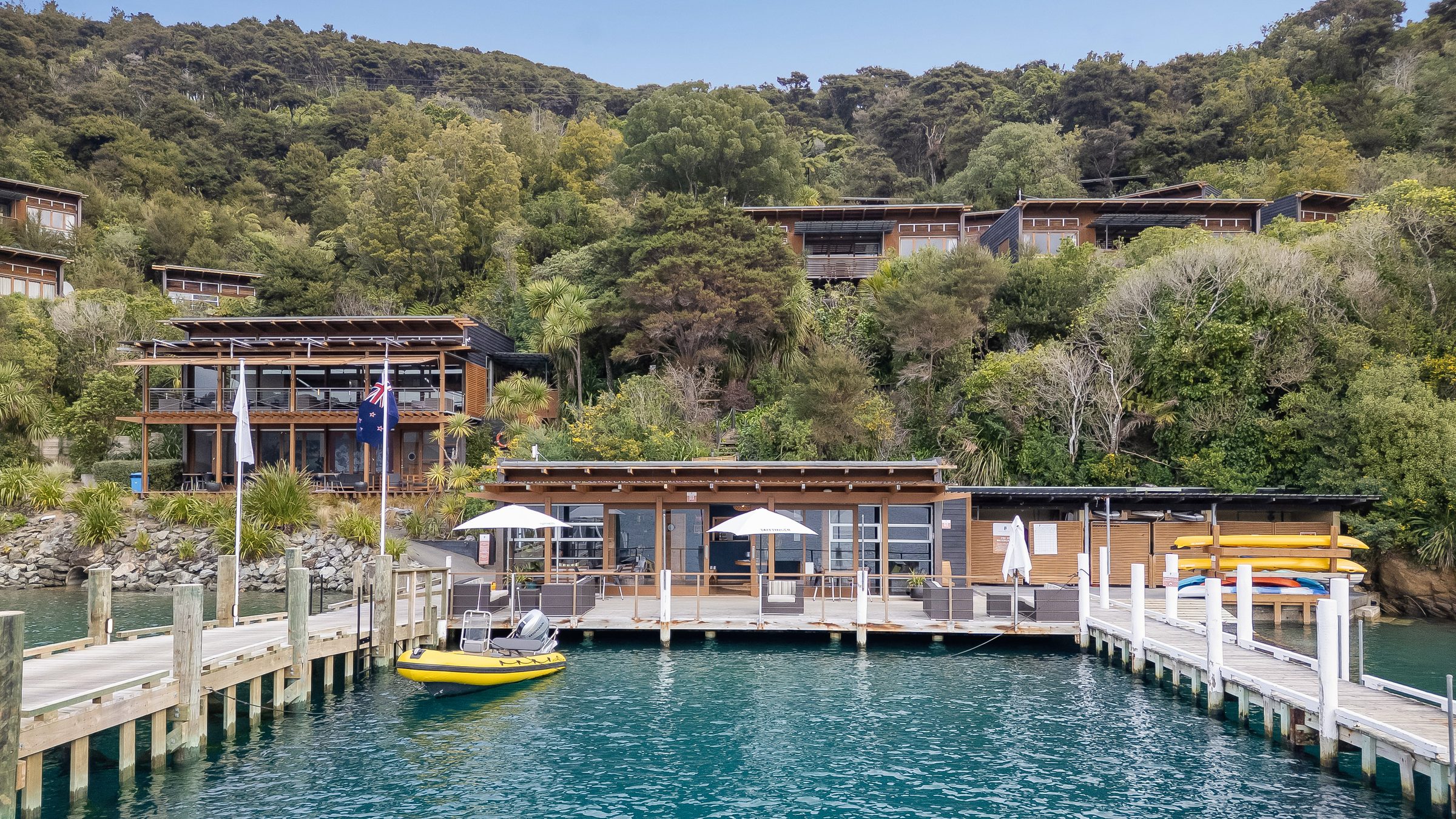 Lodge buildings on a forested hillside above the water