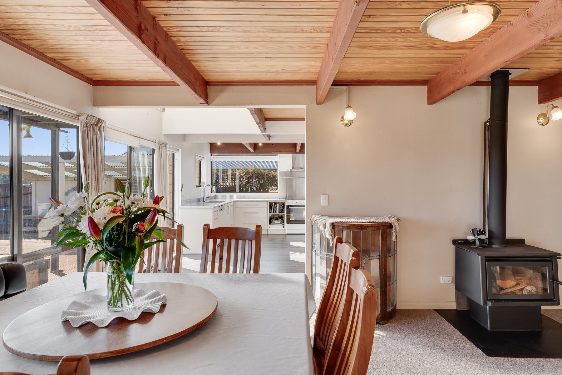 Dining area with wood-beam ceiling and fireplace