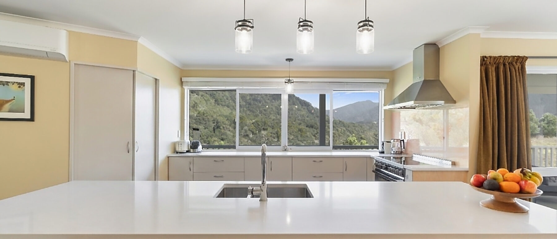 Kitchen with island bench and bush-framed windows
