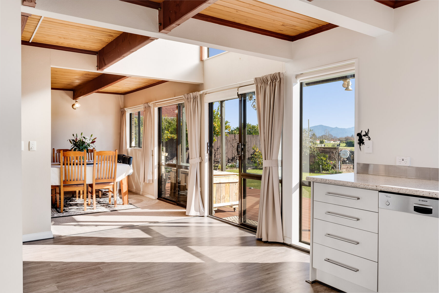 Open-plan living opening onto native bush and valley views